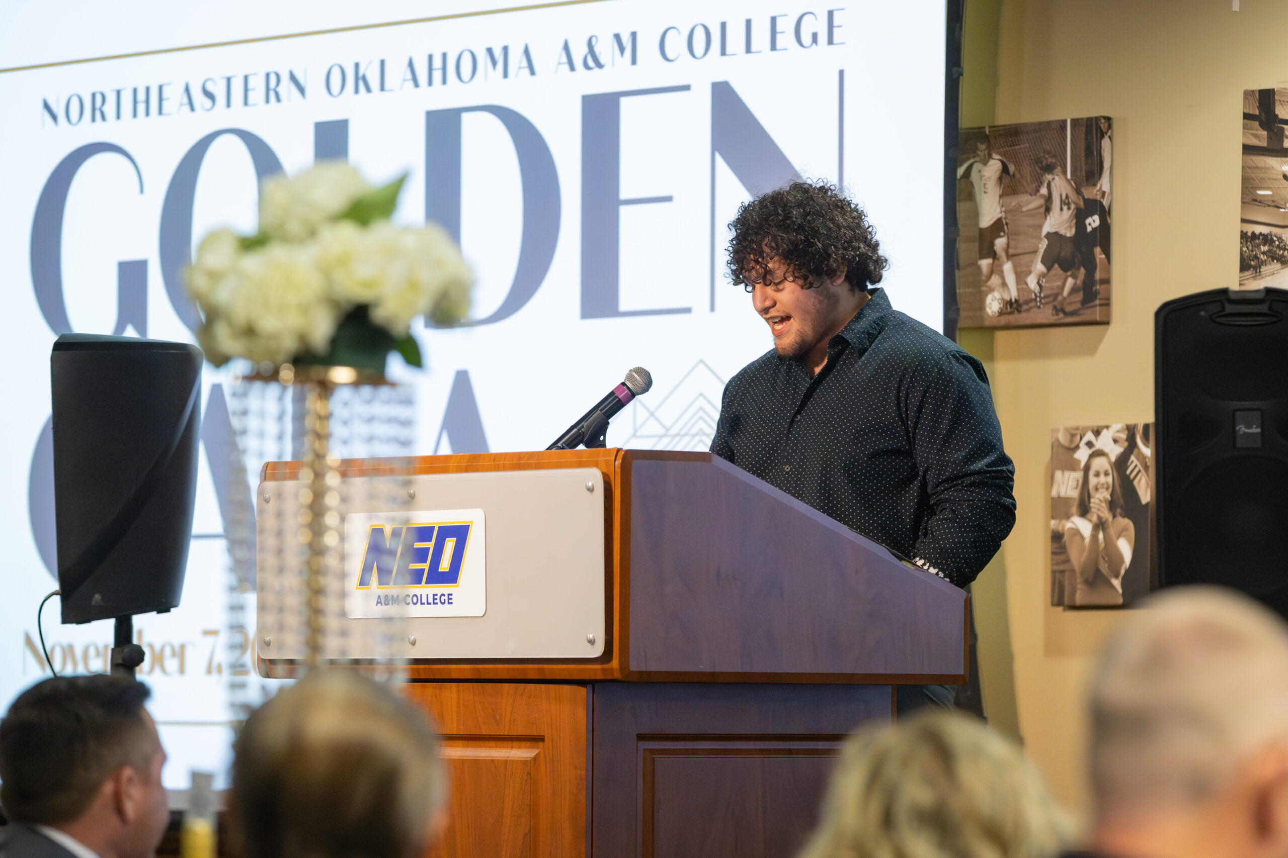 Student speaking into microphone behind podium