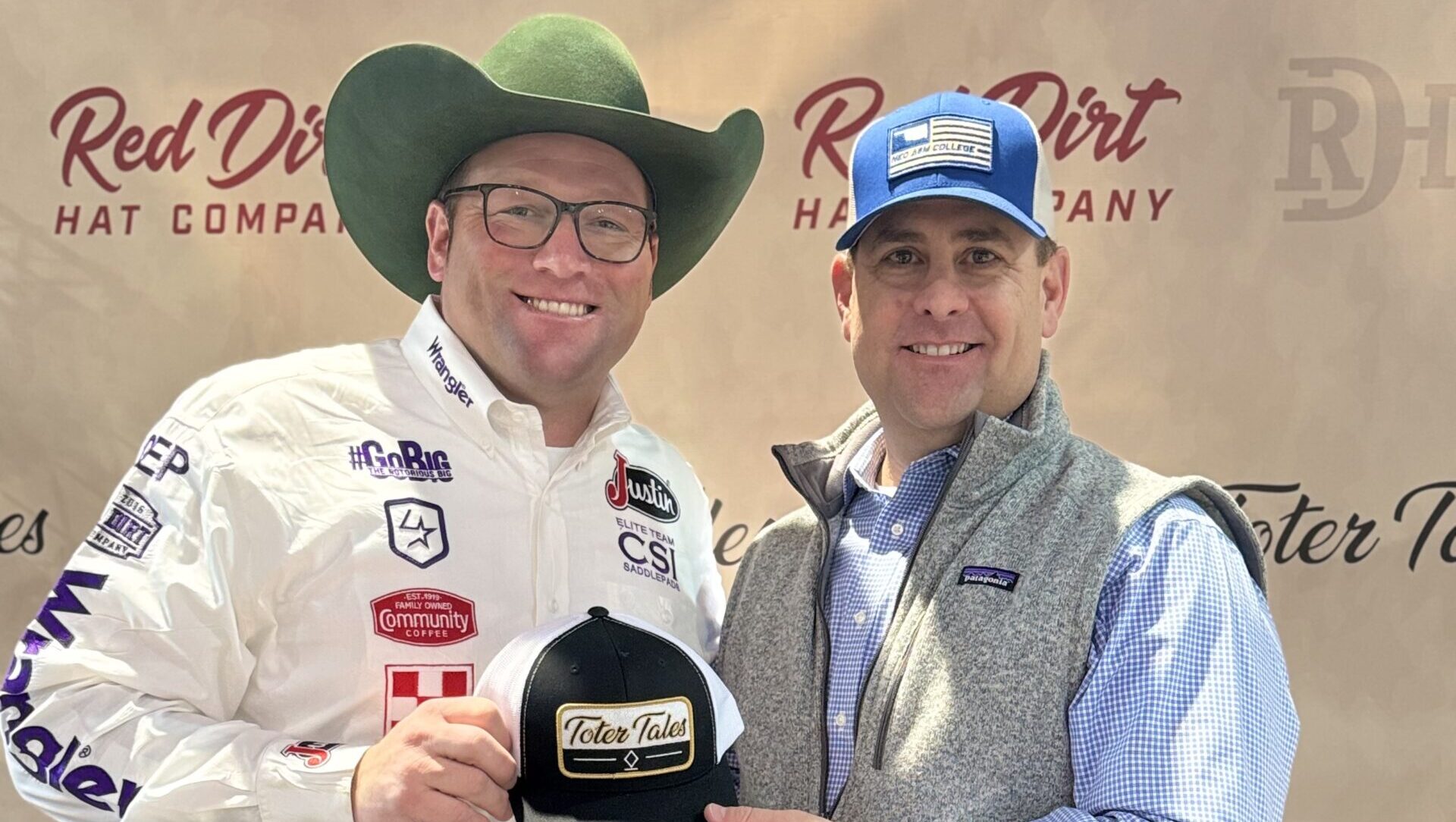 Two men pose holding an award